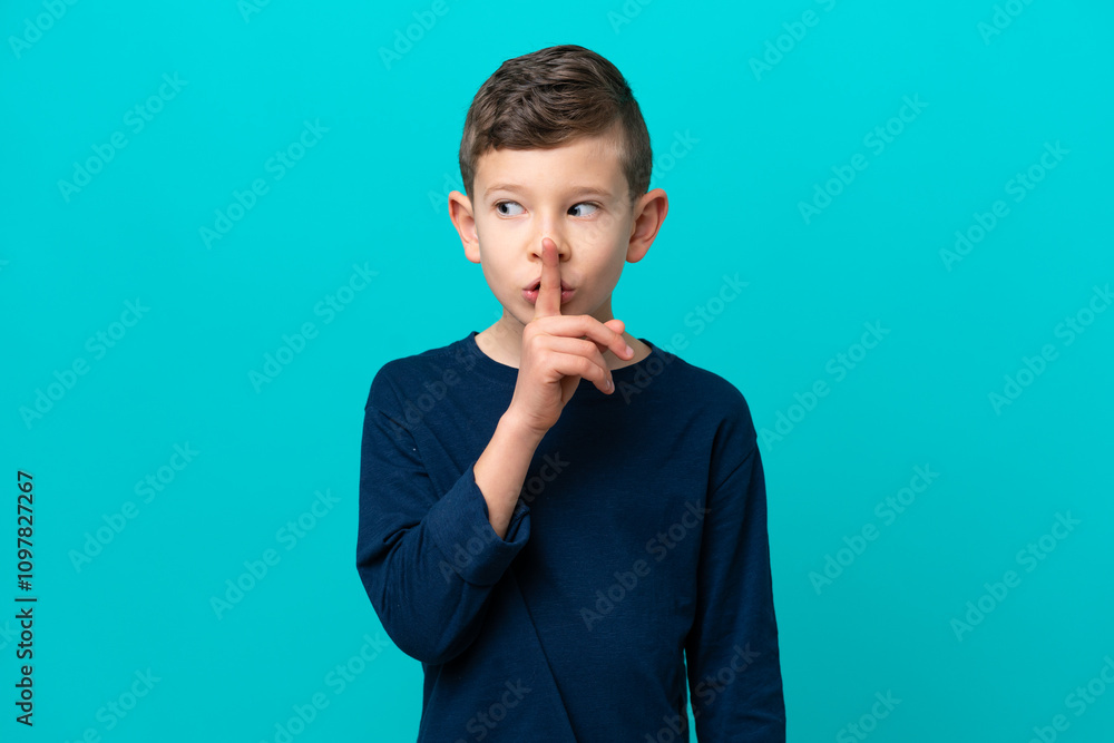 Little kid boy isolated on blue background showing a sign of silence gesture putting finger in mouth Little kid boy isolated on blue background showing a sign of silence gesture putting finger in mouth