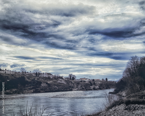 View of the river and village in Podgorica. Balkan winter. Dramatic pre-horror sky