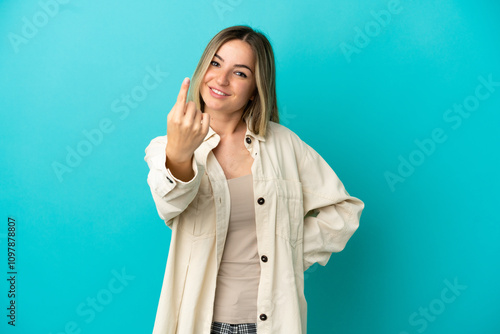 Young woman over isolated blue background doing coming gesture