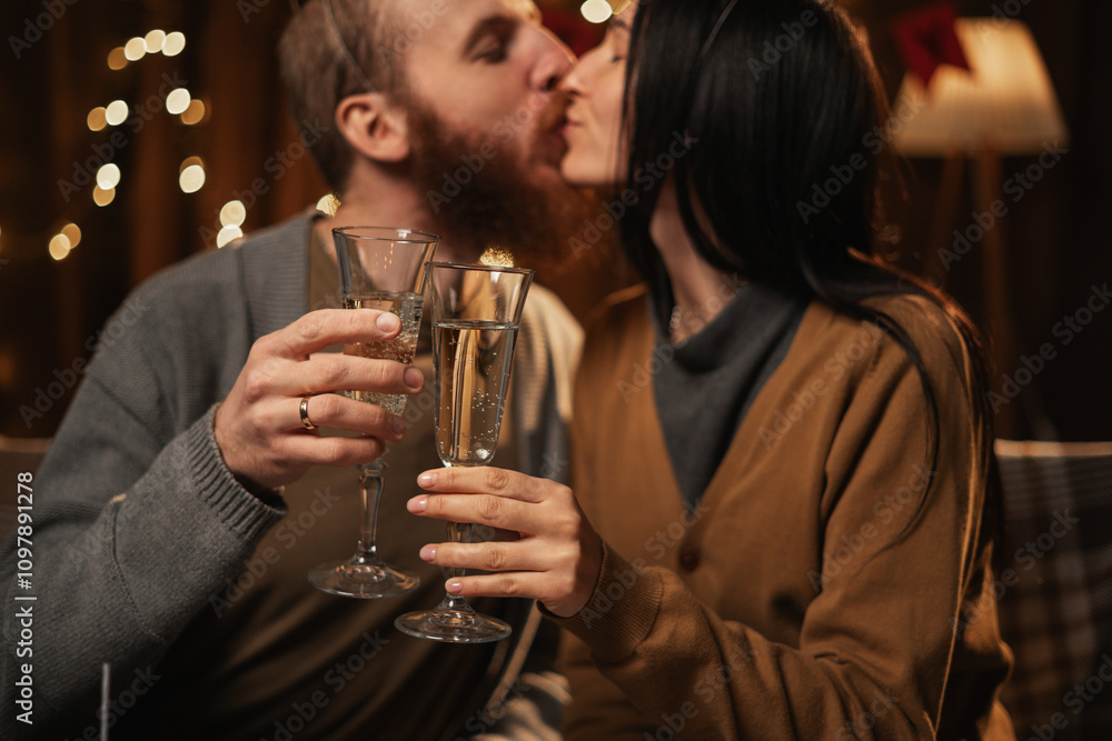 Happy young couple in love holding glasses, drinking champagne, celebrating Birthday at home together, having romantic dinner, bonding. Happy young couple in love holding glasses, drinking champagne, celebrating Birthday at home together, having romantic dinner, bonding.