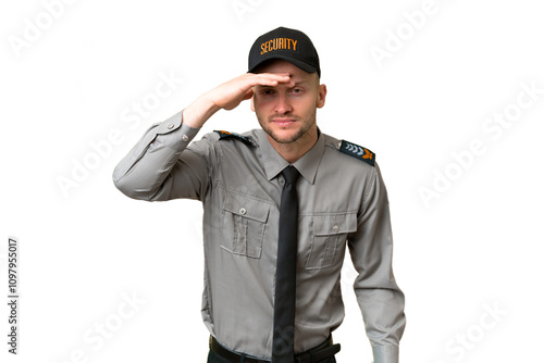 Young security caucasian man over isolated background looking far away with hand to look something