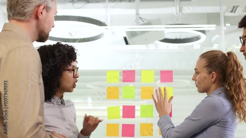 Creative group or business people planning innovation with sticky notes on glass wall.
