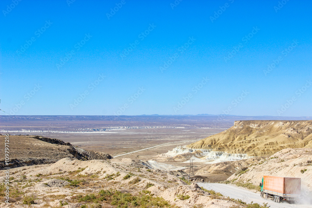 Winding road through dramatic desert canyon landscape with cargo truck Winding road through dramatic desert canyon landscape with cargo truck