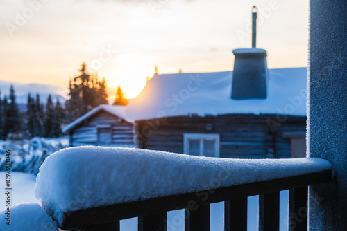 Snowy cabin view at sunset embraces winter beauty in a tranquil landscape photo