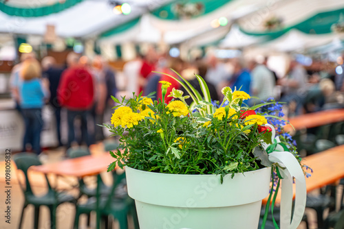 Ein Blumentopf im Focus und Menschen die Feiern im Hintergrund.