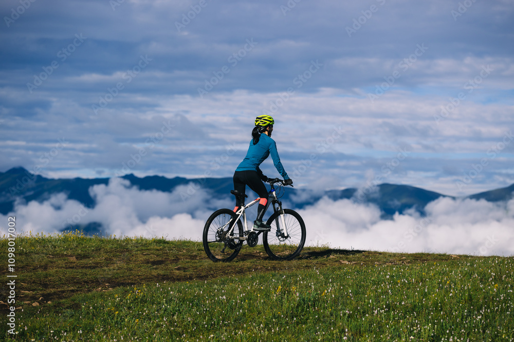 Asian woman riding mountain bike on beautiful mountain top Asian woman riding mountain bike on beautiful mountain top