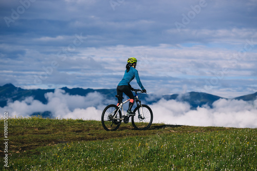 Asian woman riding mountain bike on beautiful mountain top