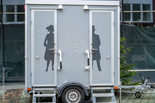 Mobile toilet trailer displaying gender symbols for men and women restrooms