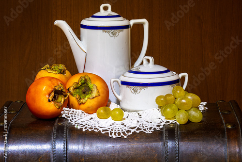 Servizio da tè con composizione di cachi e uva