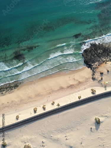 Aerial top down  view of a coastal road through the sand dunes with sea views. Taken in Fuerteventura. 

