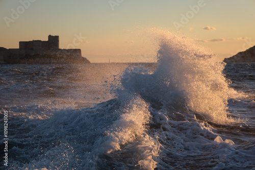 Sea wave in the rays of the setting sun against the backdrop of the Chateau d'If