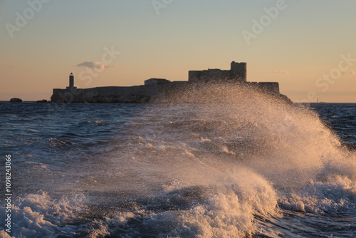 Sea wave in the rays of the setting sun against the backdrop of the Chateau d'If