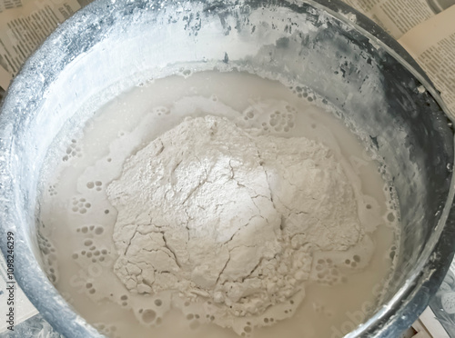 Mixing putty in a bucket. Bucket with dry building mix.