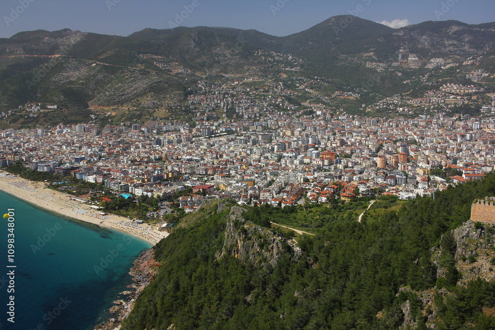 Obraz premium Landscape with harbor and Red tower in Alanya peninsula. Aerial view on city Alanya in southern coast of Turkey. Antalya district.
