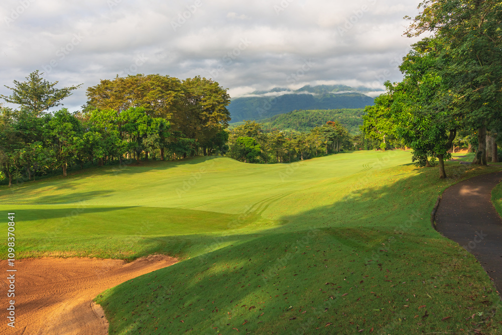 Fototapeta premium Panorama View of Golf Course with putting green in Taman Dayu Pandaan, Pasuruan, East Java, Indonesia. Golf course with a rich green turf beautiful scenery.
