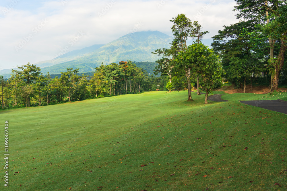 Obraz premium Panorama View of Golf Course with putting green in Taman Dayu Pandaan, Pasuruan, East Java, Indonesia. Golf course with a rich green turf beautiful scenery. 