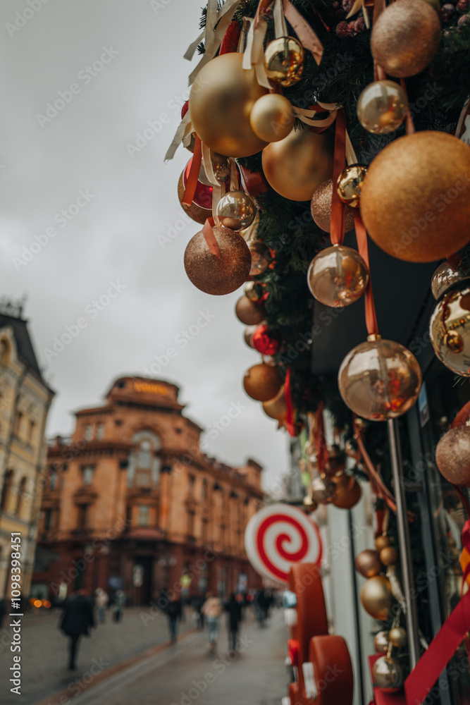 Fototapeta premium Christmas in the city, outdoor festive decor with golden Christmas balls, New Year winter composition