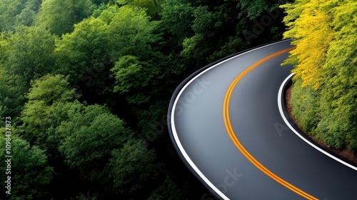 An aerial perspective highlighting a sharply curved road bordered by lush greenery, suggesting a thrilling drive and an encounter with dramatic scenic beauty. photo