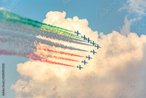 Fighter jets performing airshow with colorful exhaust streams in scenic clouds