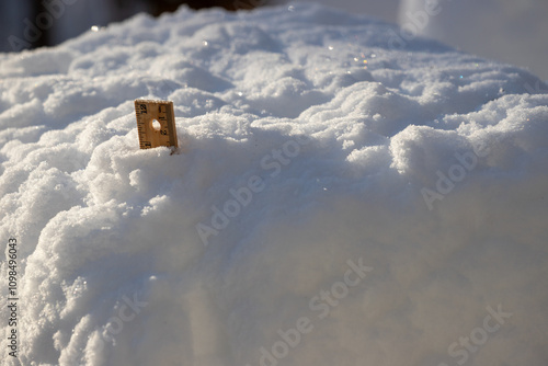 ruler measuring stick in snow in winter at sun rise