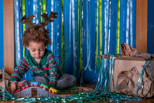 Foto Toddler plays with a train set at a Christmas party