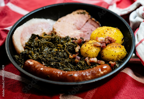 Norddeutsches Nationalgericht Grünkohl mit Schweinebacke Kohlwurst und Röstkartoffeln photo