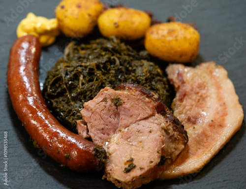 Norddeutsches Nationalgericht Grünkohl mit Schweinebacke Kohlwurst und Röstkartoffeln photo