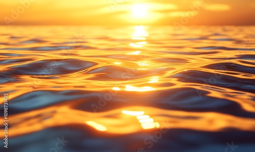 A serene water surface reflecting the warm golden hues of a sunrise