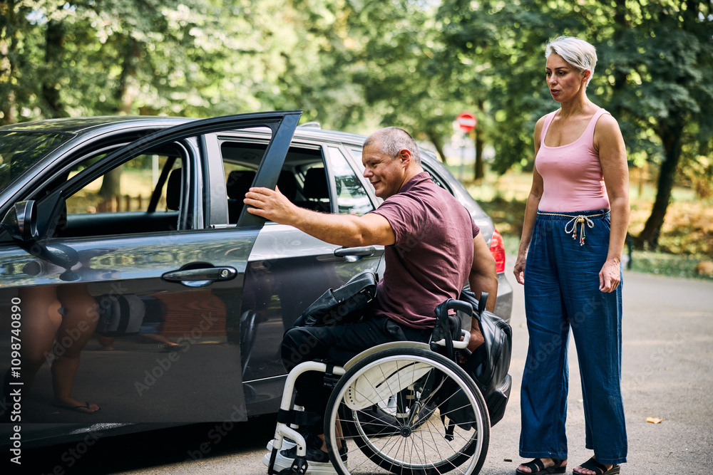 Naklejka premium Man in Wheelchair Assisting With Car Transportation Outdoors