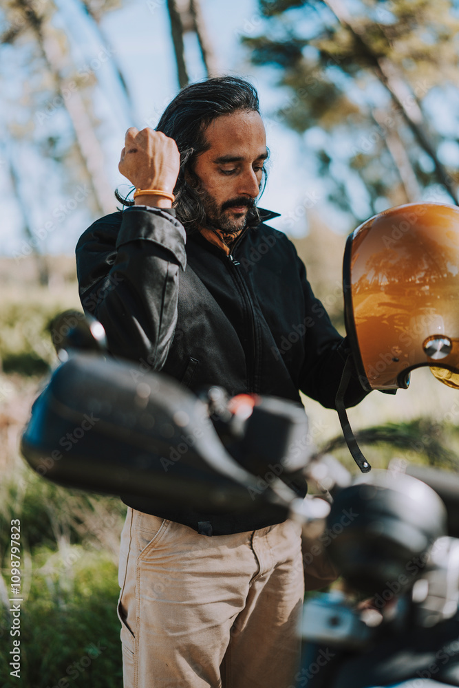 Hombre con barba y estilo alternativo con moto de campo en paso de bosque