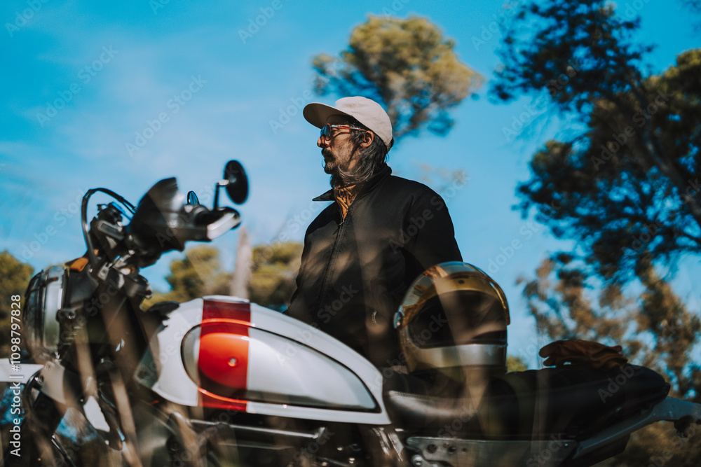 Hombre con barba y estilo alternativo con moto de campo en paso de bosque