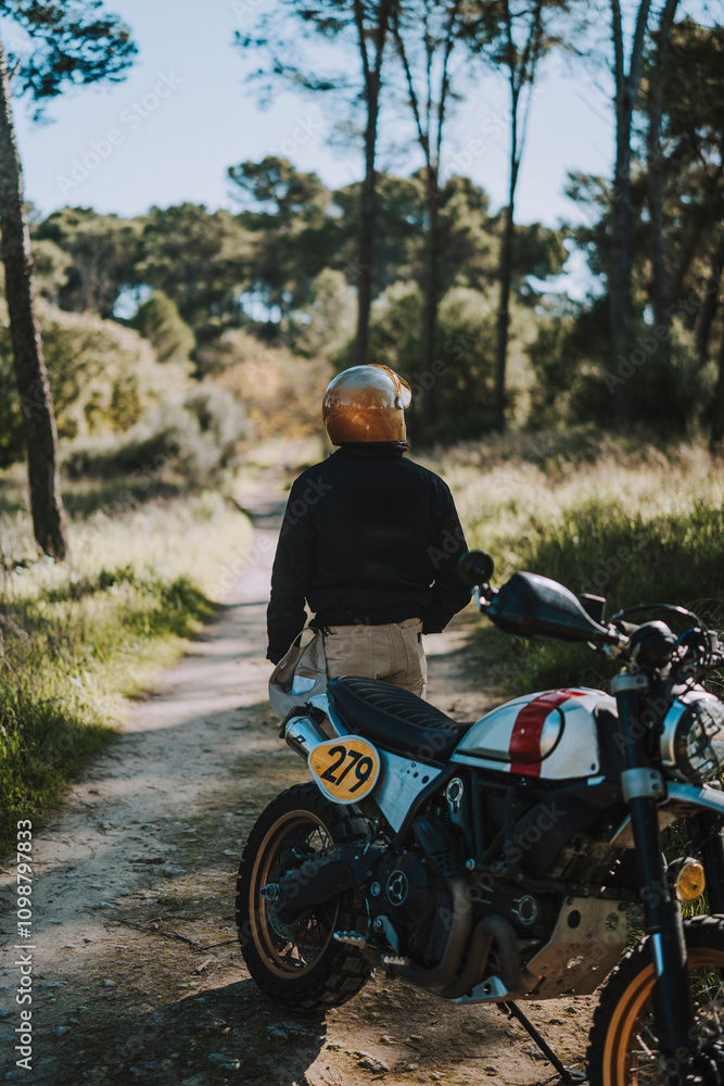 Hombre con barba y estilo alternativo con moto de campo en paso de bosque
