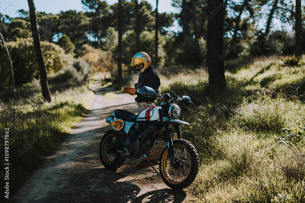 Hombre con barba y estilo alternativo con moto de campo en paso de bosque