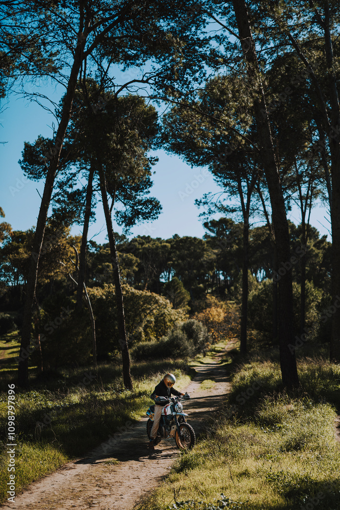 Hombre con barba y estilo alternativo con moto de campo en paso de bosque
