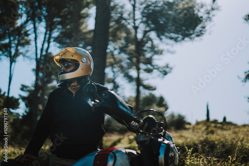 Obraz na płótnie Hombre con barba y estilo alternativo con moto de campo en paso de bosque w salonie