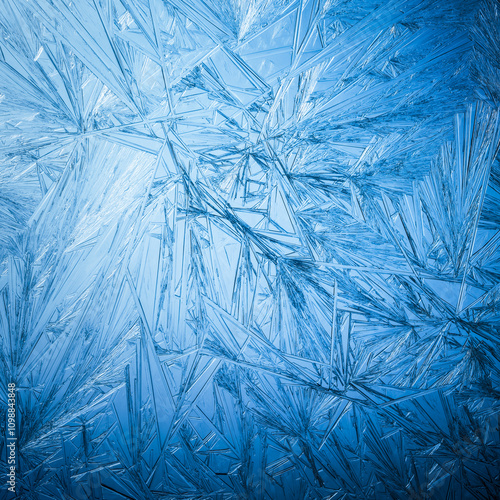 Snowflake frost patterns on glass. Vivid ice crystal textures on clear glass window. Frozen surface, snow flake structure, or freezing cold winter background.