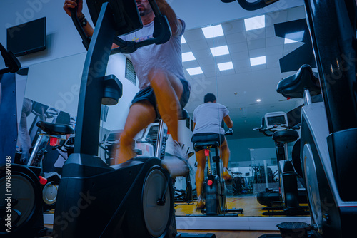 Hombre deportista entrenando en gimnasio sobre bicicleta elíptica. photo