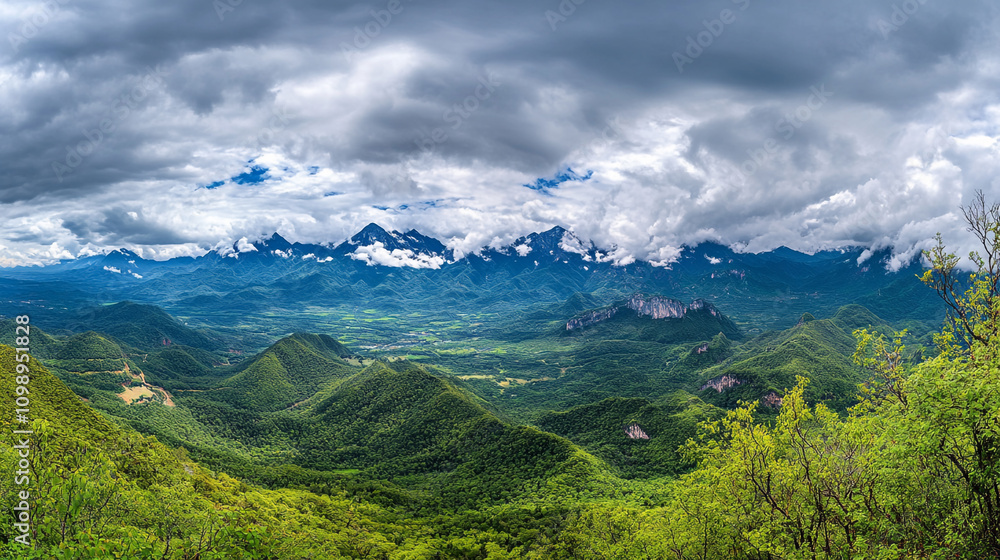 Fototapeta premium Expansive mountain landscape under cloudy skies in the early afternoon light