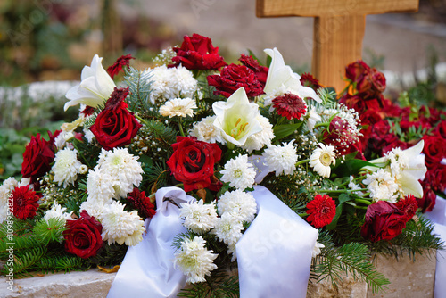 Konstfotografi funeral flowers of red roses and white dahlias and lilies with white ribbon on a