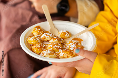 food truck food at event – plate of mini pancakes with icing sugar and syrup photo