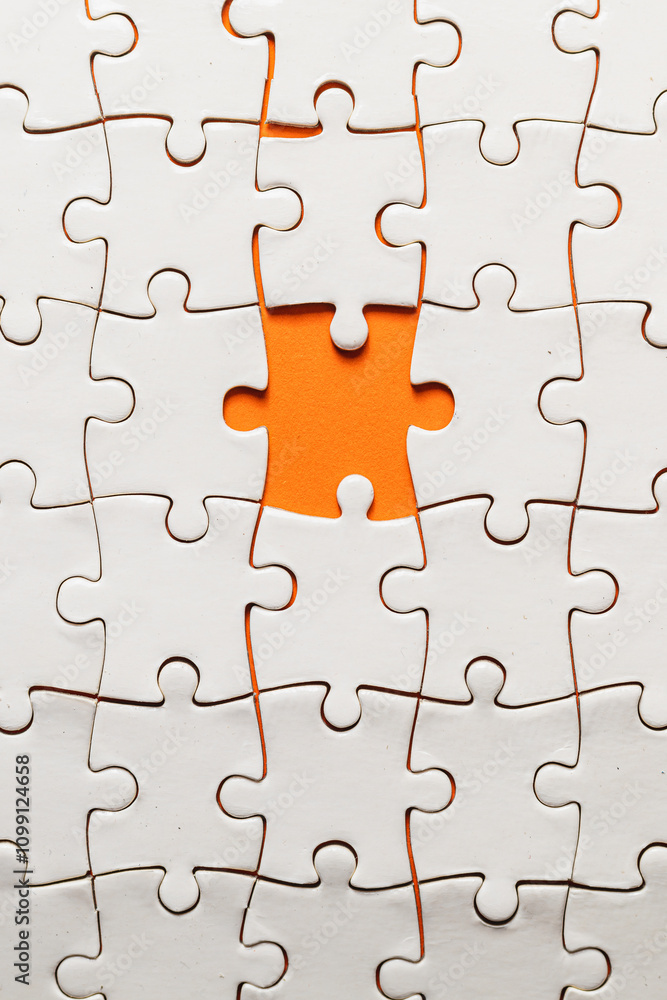 Fototapeta premium Conceptual photo of a puzzle, missing piece, on an orange background