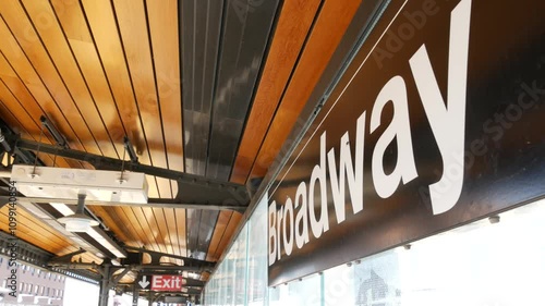 New York subway station Broadway text sign. Metropolitan platform, United States public metro transportation. Elevated outdoor railway line perspective, Astoria, Queens. NYC passenger railroad traffic