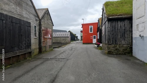 Walking down the streets of Nólsoy, Faroe Islands. Rustic Scandinavian style architecture in this remote fishing village. Grass rooftops are commonl seen in this area. Located on the North Atlantic.