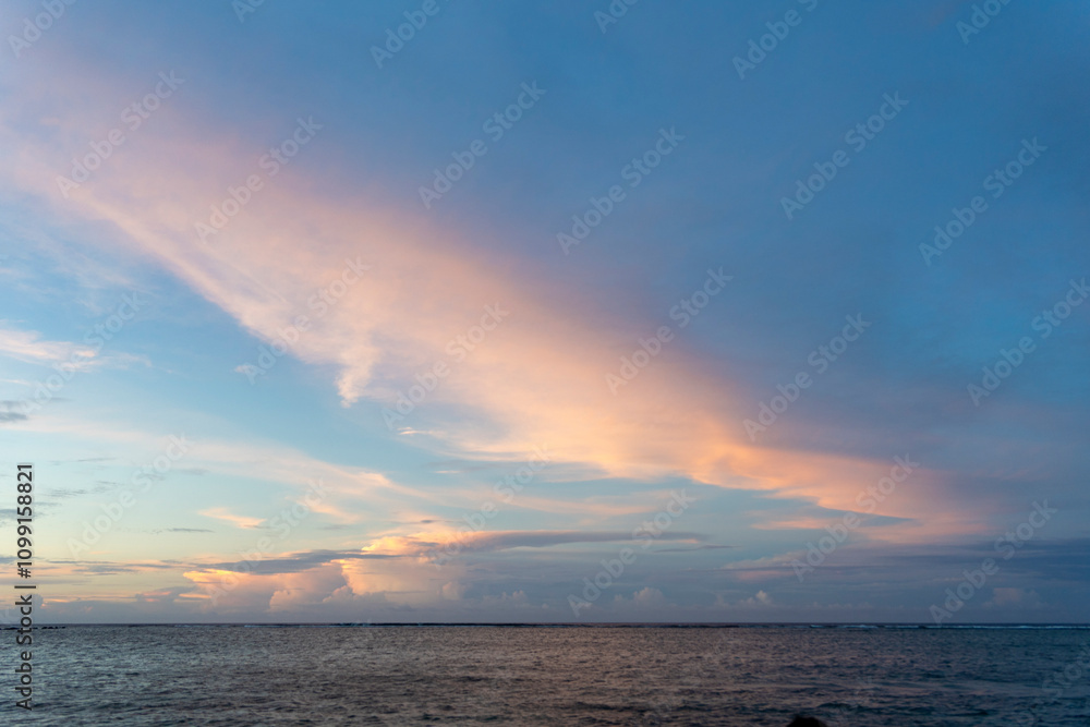 Fototapeta premium Sunset sky over the tranquil waters of Guam showcasing vibrant colors and serene atmosphere
