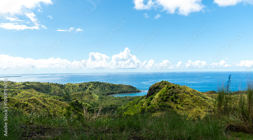 Fototapeta premium Lush green hills and sparkling waters of Guam's breathtaking landscape