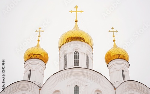 A photo of the Cathedral in Veliky Novgorod with its golden domes and crosses shining brightly, set against a blank white sky, showcasing the intricate details of Russian Orthodox architecture