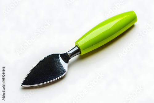 A vibrant lime green handled cheese spreader knife, isolated on a white background.  Perfect for culinary, kitchenware, or food blogs. photo