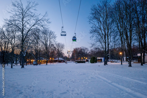 Obraz na płótnie Beautiful winter in the park. Illuminated restaurants in the background. The longest lowland cableway in Europe