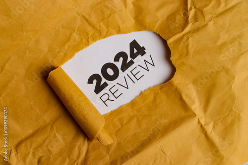 A yellow piece of paper with a hole torn in it. Through the hole, a white piece of paper is visible with the text 
