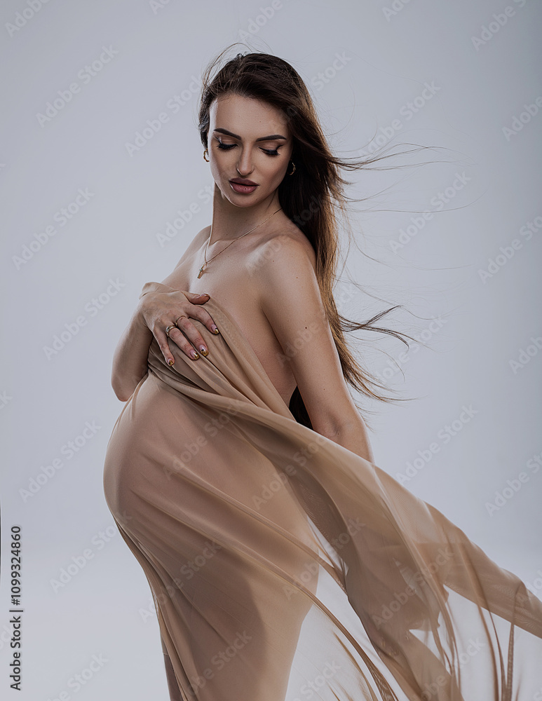 Fototapeta premium beautiful pregnant woman in studio with light drapery like virgin mary